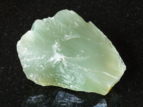 light green crystal rock close up view dark background