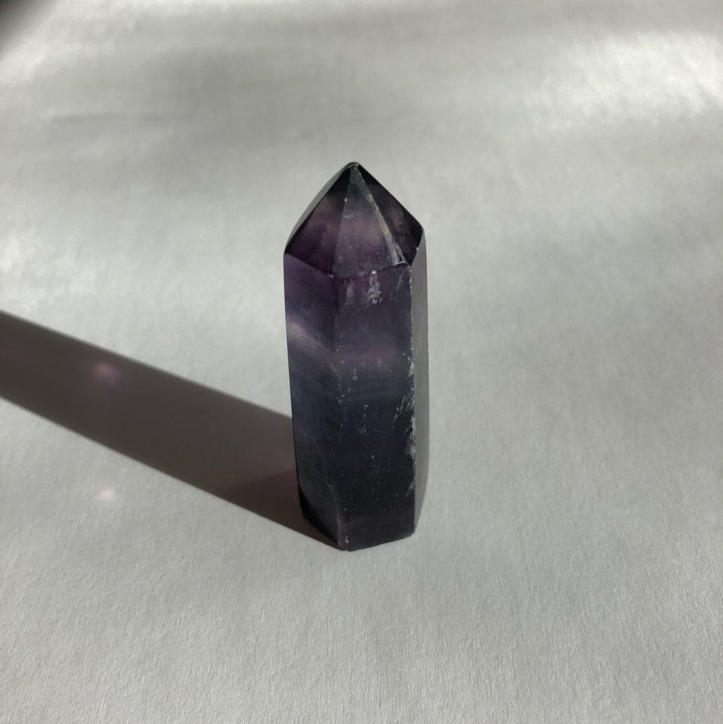 Rainbow Fluorite Point on white background