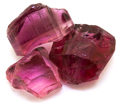 three pink tourmaline stones on a white background close up view