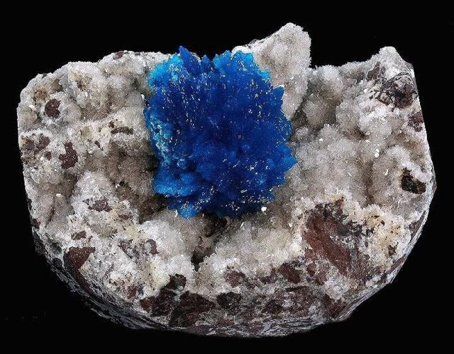 raw blue crystal on a black background close up front view