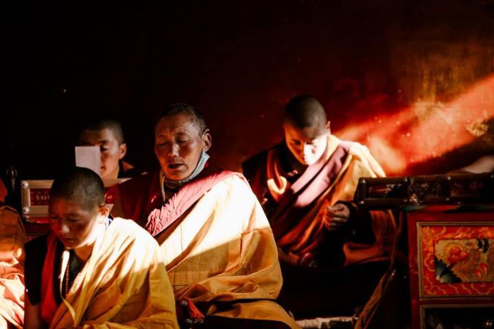 group of Buddhist monks light piercing through the window shining on them