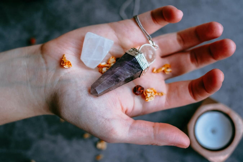 white crystal and purple prism necklace place on a right hand