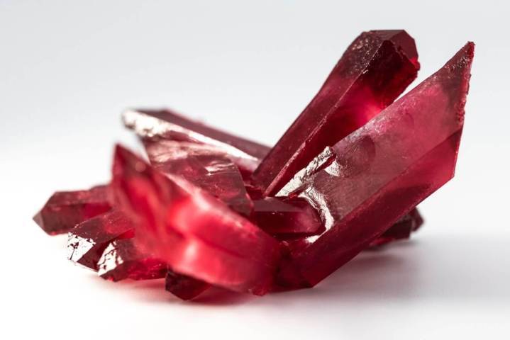 polished red crystal rock close up view white background