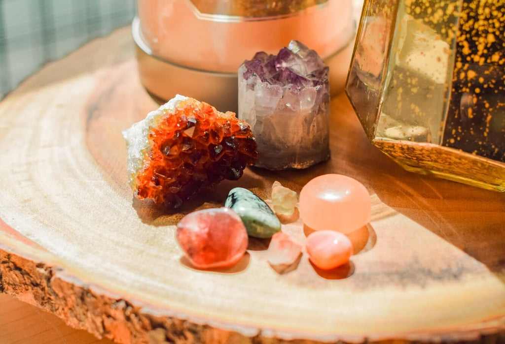 different types of crystal rocks and smooth stones placed on a wooden surface