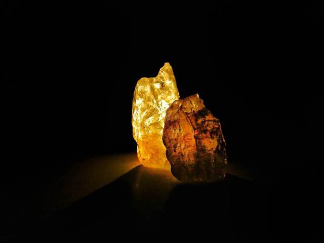 two pieces of crystal rock yellow and brown black background
