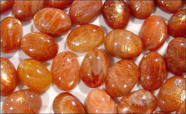 many pieces of smooth polished orange stones top close up view