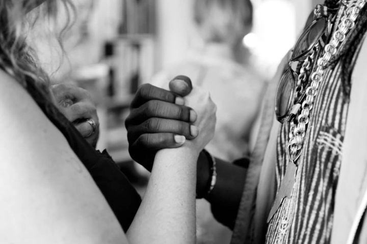 two people holding hands chest level black and white