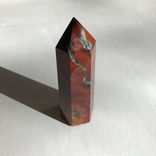 Red Jasper Point crystal on white background