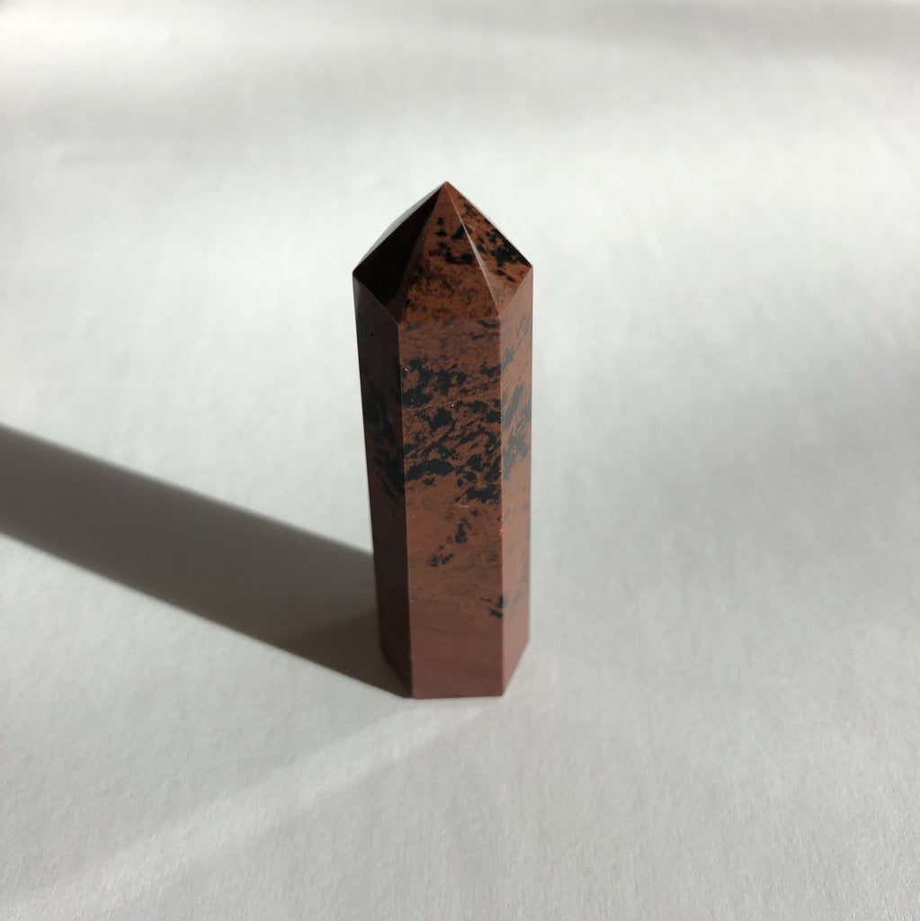 Red Obsidian Point crystal on white background