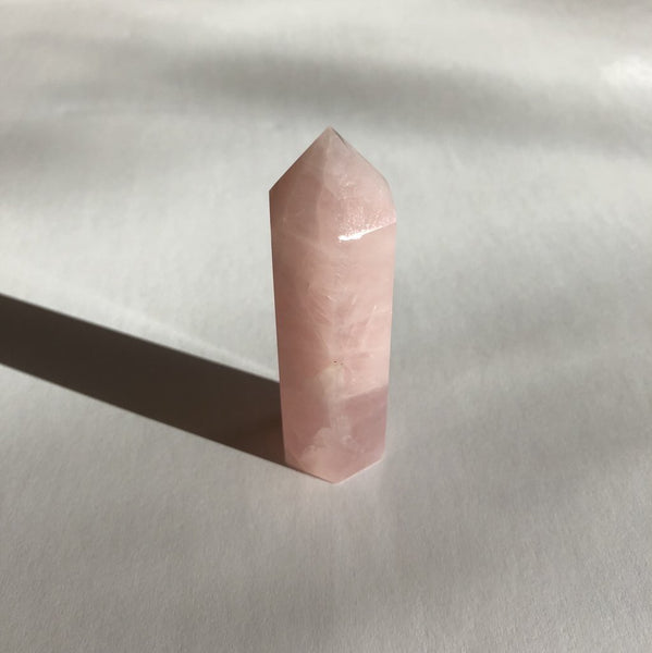 Rose Quartz Point crystal on white background