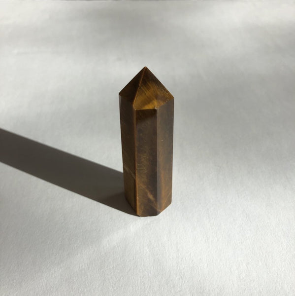 Tigers Eye Point crystal on white background